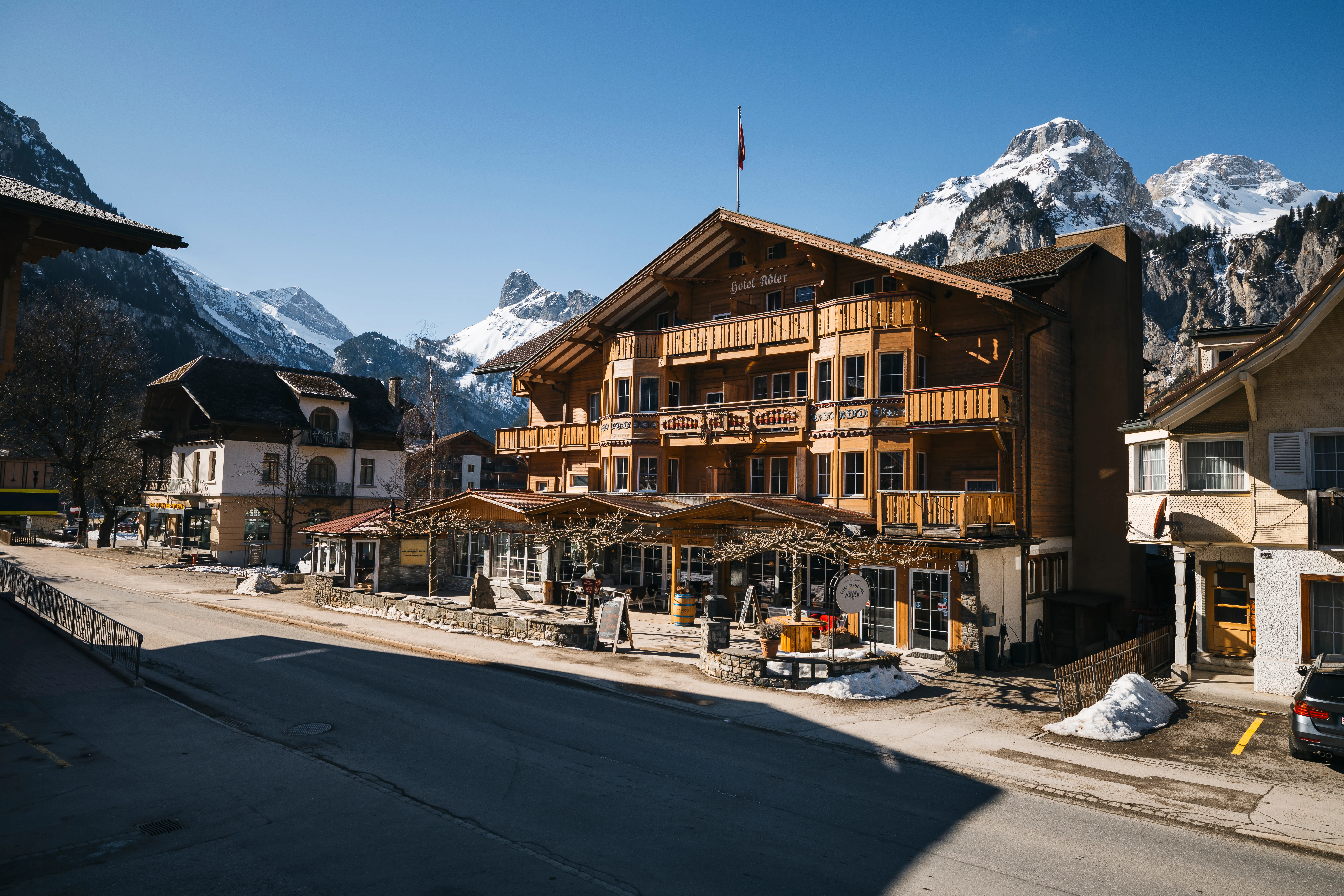 Chalet-Hotel Adler in Kandersteg im Winter, Strassenansicht mit Restaurant-Terrasse