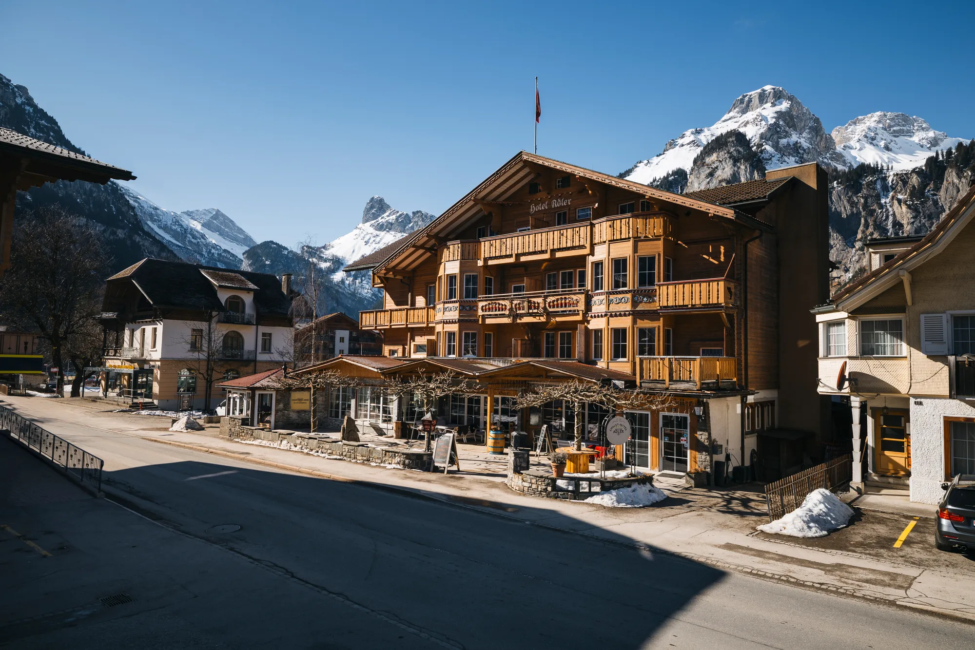 Chalet-Hotel Adler in Kandersteg im Winter, Strassenansicht mit Restaurant-Terrasse
